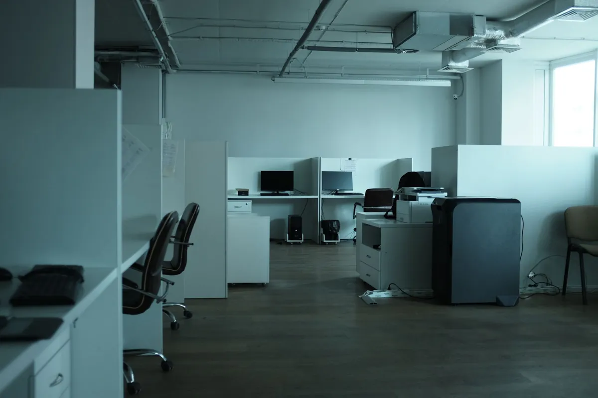 Empty modern office with desks and chairs in soft daylight