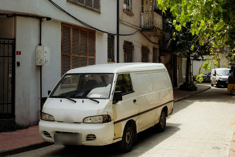 White work van parked on a quiet cobbled street